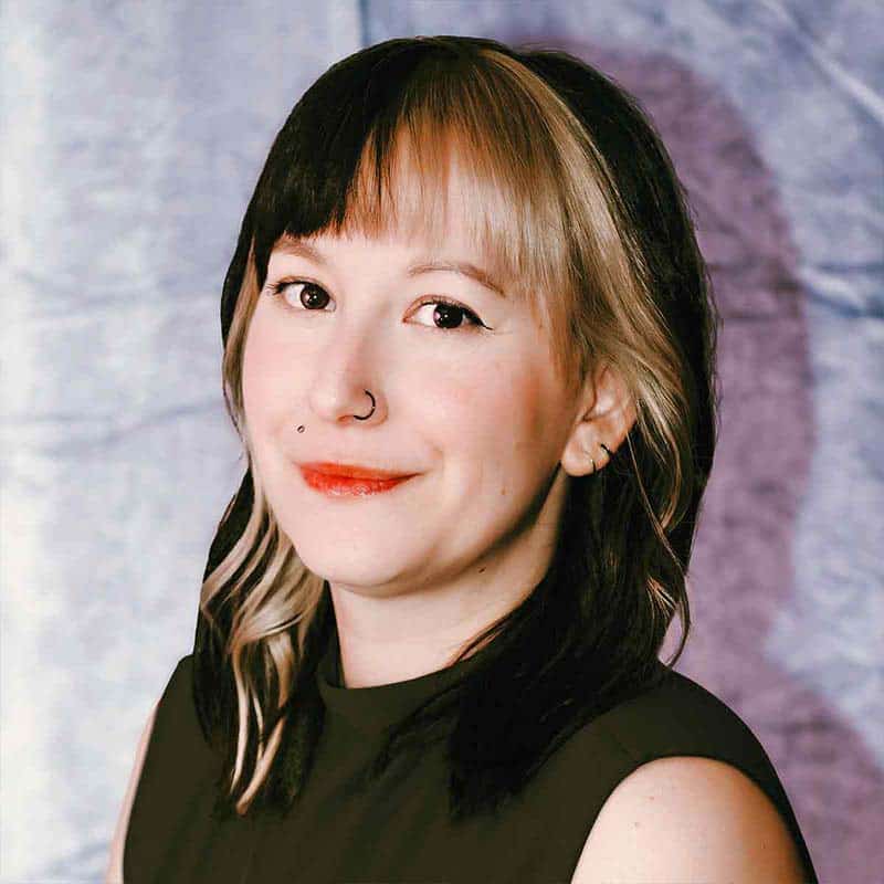 A headshop of a woman with brown hair and blonde color blocking.